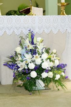 Purple and white flowers decorate church on wedding day