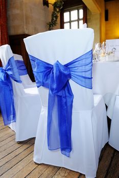 Blue ribbon chair cover tied in bow at wedding reception