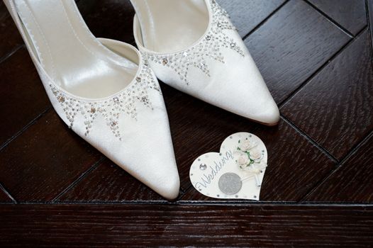 Brides shoes closeup detail and lucky sixpence