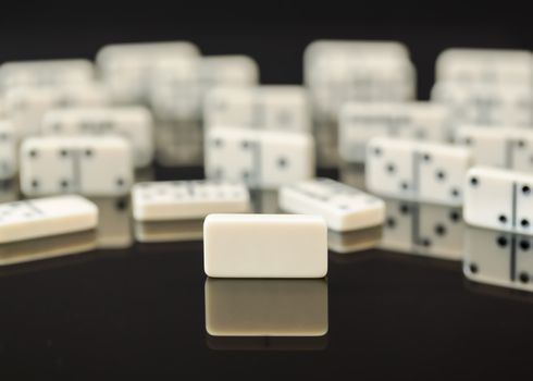 Single blank domino in front of peers as concept image for being different, blank slate, open to change, flexible, malleable