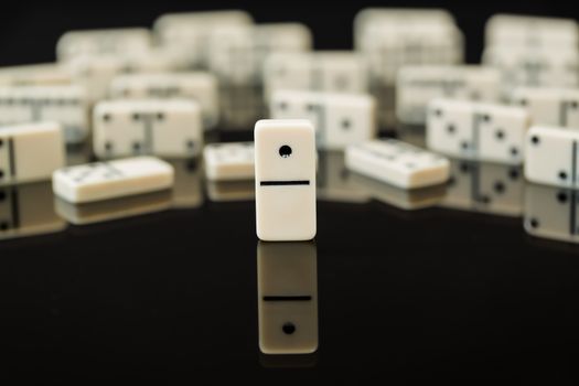 Number One domino in front of peers as concept image for success, innovation, leadership, winning and leader of the pack