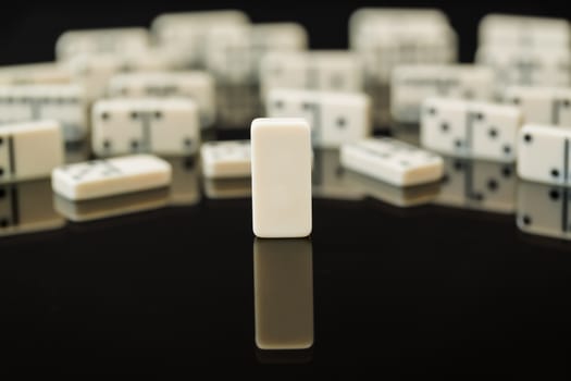 Single blank domino in front of peers as concept image for being different, blank slate, open to change, flexible, malleable