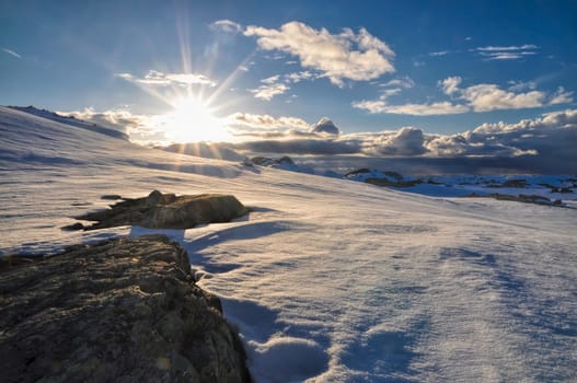 Panoramic view of sun setting down over mountains near Trolltunga, Norway