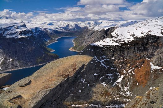 Panoramic view of the sun shining on the fjord under Trolltunga, Norway 