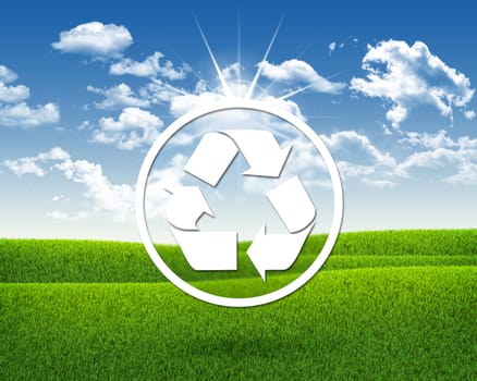 White symbol recycling. Green grass and blue sky as backdrop