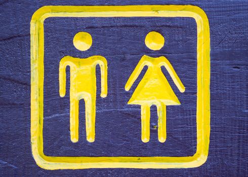Man & Woman restroom sign on wood