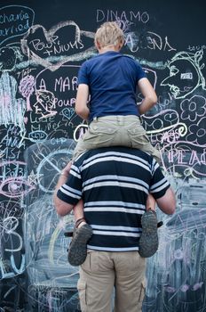 father and son writing on big blackboard