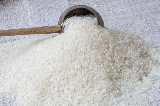 Uncooked jasmine rice in a wood bowl.