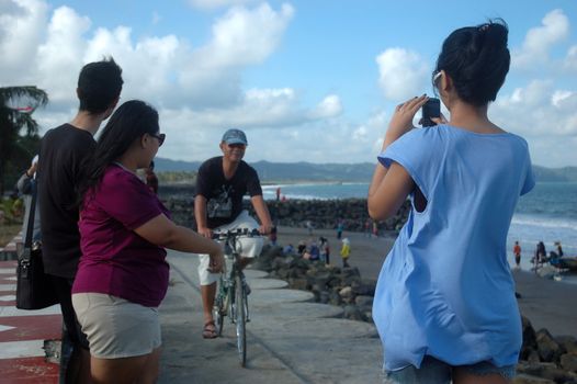 Pangandaran, Indonesia - July 16, 2011: Man riding a bike at Pangandaran beach shore, West Java-Indonesia.