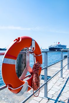 Red Lifebuoy (life preserver) at the laguna in front of a large cruise ship