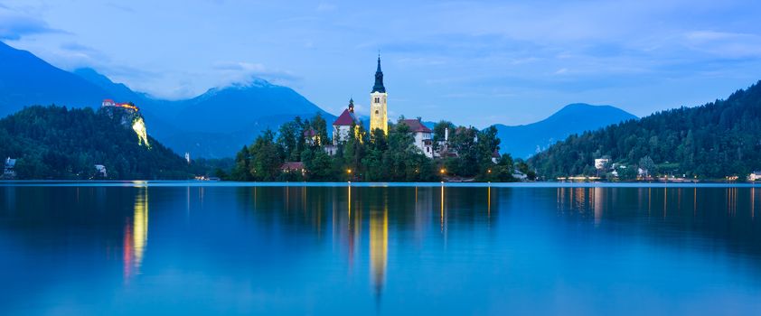 View of Julian Alps and Lake Bled with St. Marys Church of the Assumption on the small island at dusk. Bled, Slovenia, Europe. 