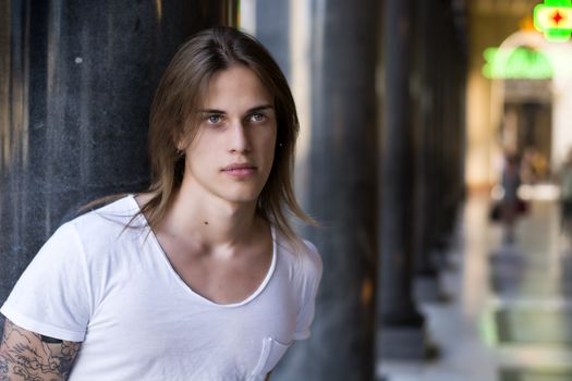 Handsome Long Hair Man on White Shirt Standing Besides Hallway