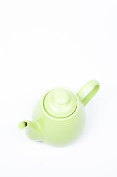 Green teapot on a white background with a single in the studio.