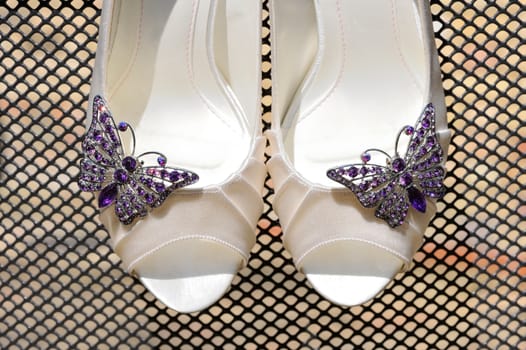 Brides shoes closeup show purple butterfly detail 