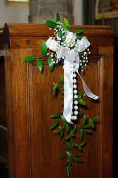 White roses decorate inside of church on wedding day