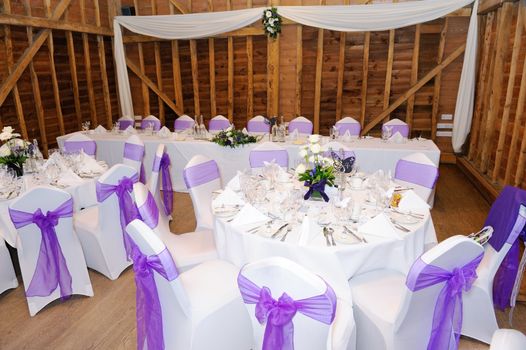 Wedding reception setting with white and purple decorations