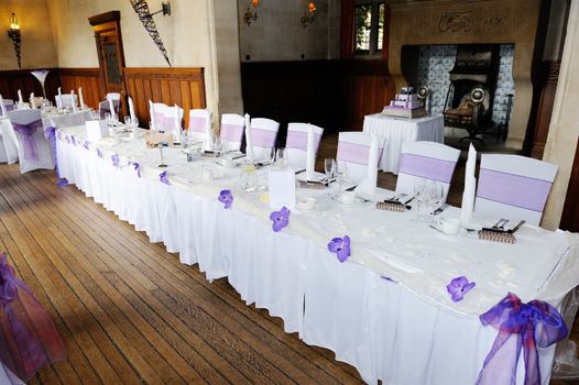 head table at wedding reception decorated with purple flowers