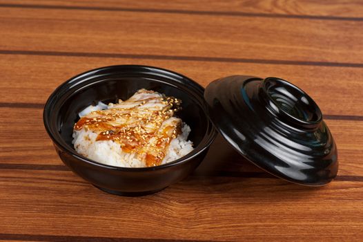 Japanese cuisine, eel with rice at black plate