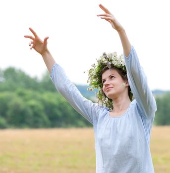 portrait of a young woman wearing a crown of summer wildflowers