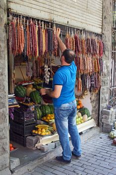 TBILISI, GEORGIA - JUNE 28, 2014: Man selling Georgian sweets at a typic convenience store on June 28, 2014 in Tbilisi, Georgia, East Europe