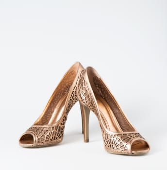 Woman gold shoes on white background