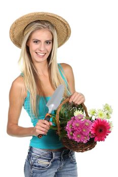 Gorgeous blond woman in straw hat holding a basket full of beautiful flowers