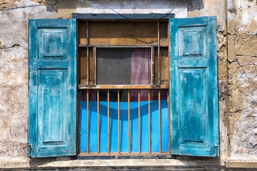 Window in old building with iron bars and blue shutters in Bangkok