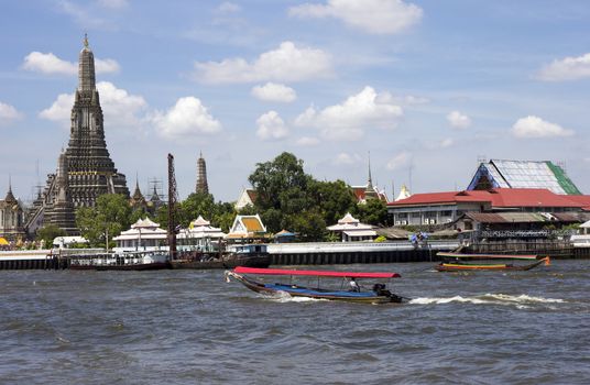 Boats on the Chao Phraya River passing Wat Arun, Bangkok, Thailand