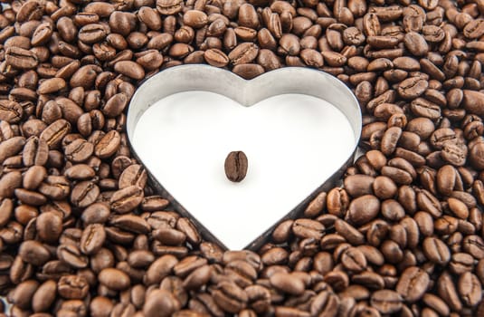 Coffee beans in the white heart surrounded by coffee beans.