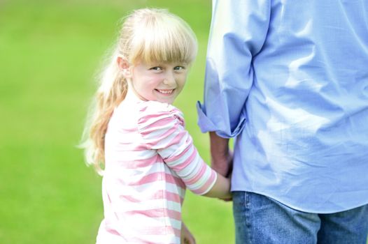 Cute little girl holding her father's hand