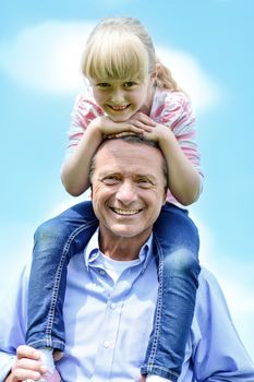 Father carrying little daughter on his shoulders