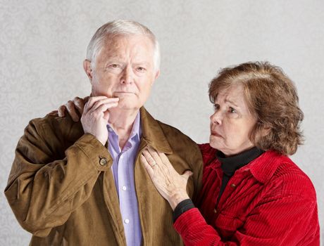 Worried wife holding concerned husband in jacket