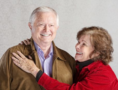 Smiling senior woman holding her happy husband
