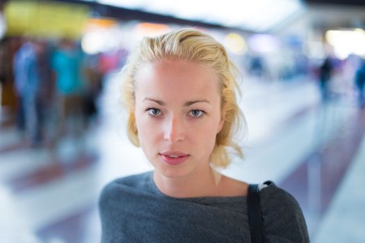 Young woman  waiting on the platform of a railway station for their train. to arrive.