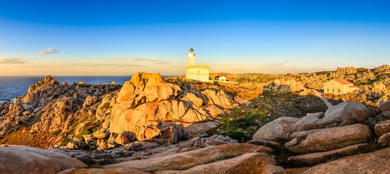 Rocky ocean coastline panorama with lighthouse at sunset, Sardinia, Italy