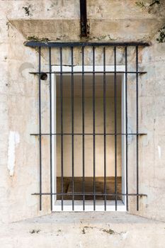 Fort de Soto museum housing old artillery and military guns with solid barred iron grid windows into stone block rooms like prison cells