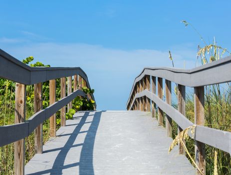 Wooden boardwalk to ocean amond sea oats on Sunset Beach at southern tip of Treasure Island Florida on Gulf of Mexico