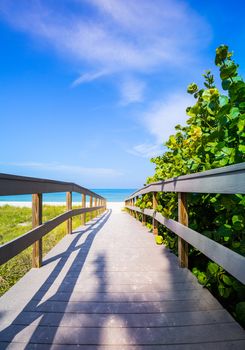 Wooden boardwalk to ocean amond sea oats on Sunset Beach at southern tip of Treasure Island Florida on Gulf of Mexico