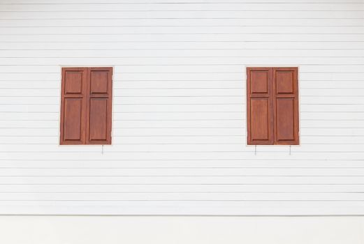 two brown wooden windows on white wooden house