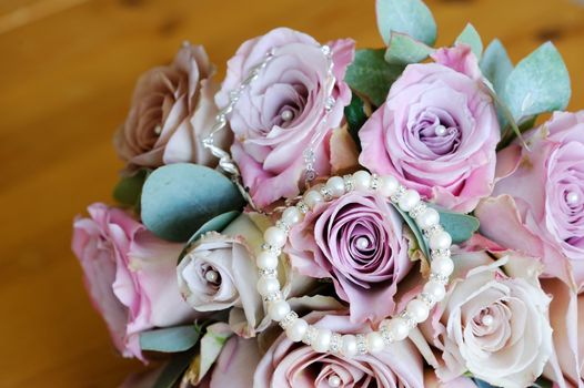 Brides pink roses and jewelry on wedding day