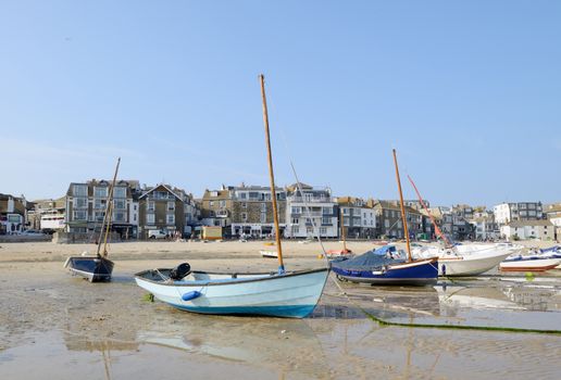 Lots of small boats on the beach at low tide in St Ives, Cornwall