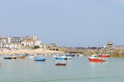 Fishing boats moored in the harbour of a cornish seaside town in the summer