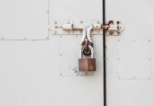 Old master key is lock on white steel door