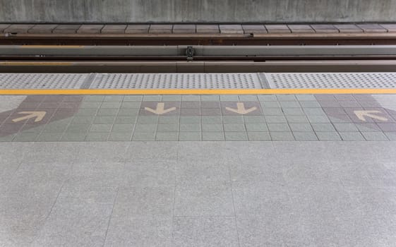 Arrow in and out on floor at sky train