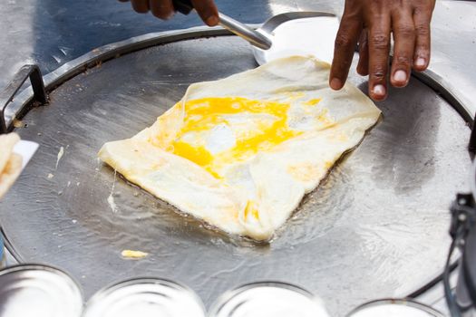 roti with egg frying on hot pan