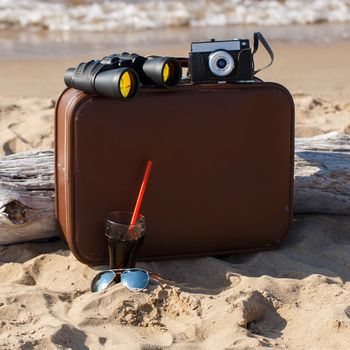 Summer, sea. Brown suitcase on the beach