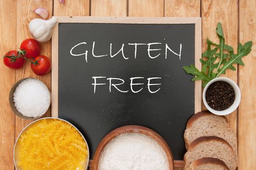 Gluten free sign handwritten on a chalk board surrounded by ingrediients