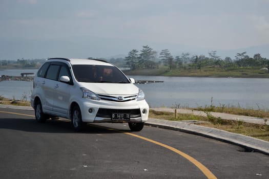 Bandung, Indonesia - August 1, 2014: White colored Daihatsu Xenia parked beside road.