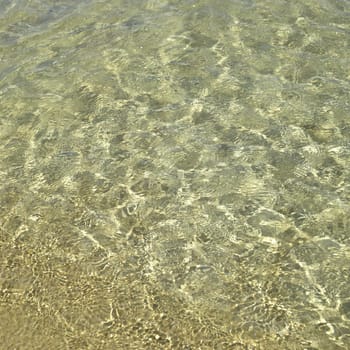 Clear ocean water on gold sand