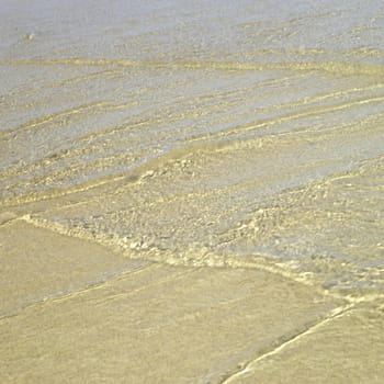 Clear ocean water on gold sand